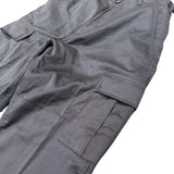 A close-up of black cargo pants showing the fabric texture, belt loops, and side cargo pockets against a plain white background.